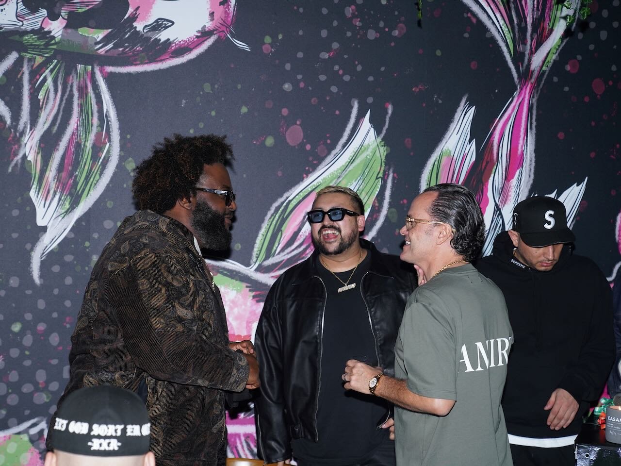 Dreamville rapper Bas, DJ Nitrane, Cherryfish partner Carlos Becerra, and DJ Dre Sinatra inside Cherryfish dining room with hand-painted mural in Pacific Beach San Diego
