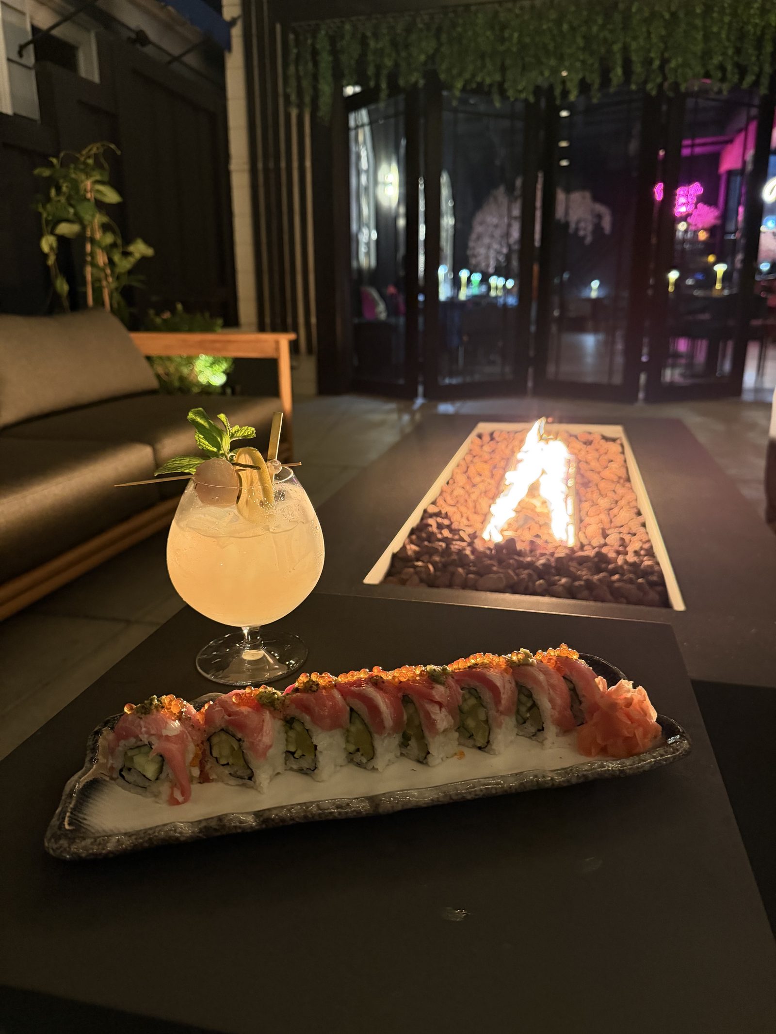 Cherryfish sushi roll and craft cocktail on the patio with fire pit at night, Pacific Beach San Diego