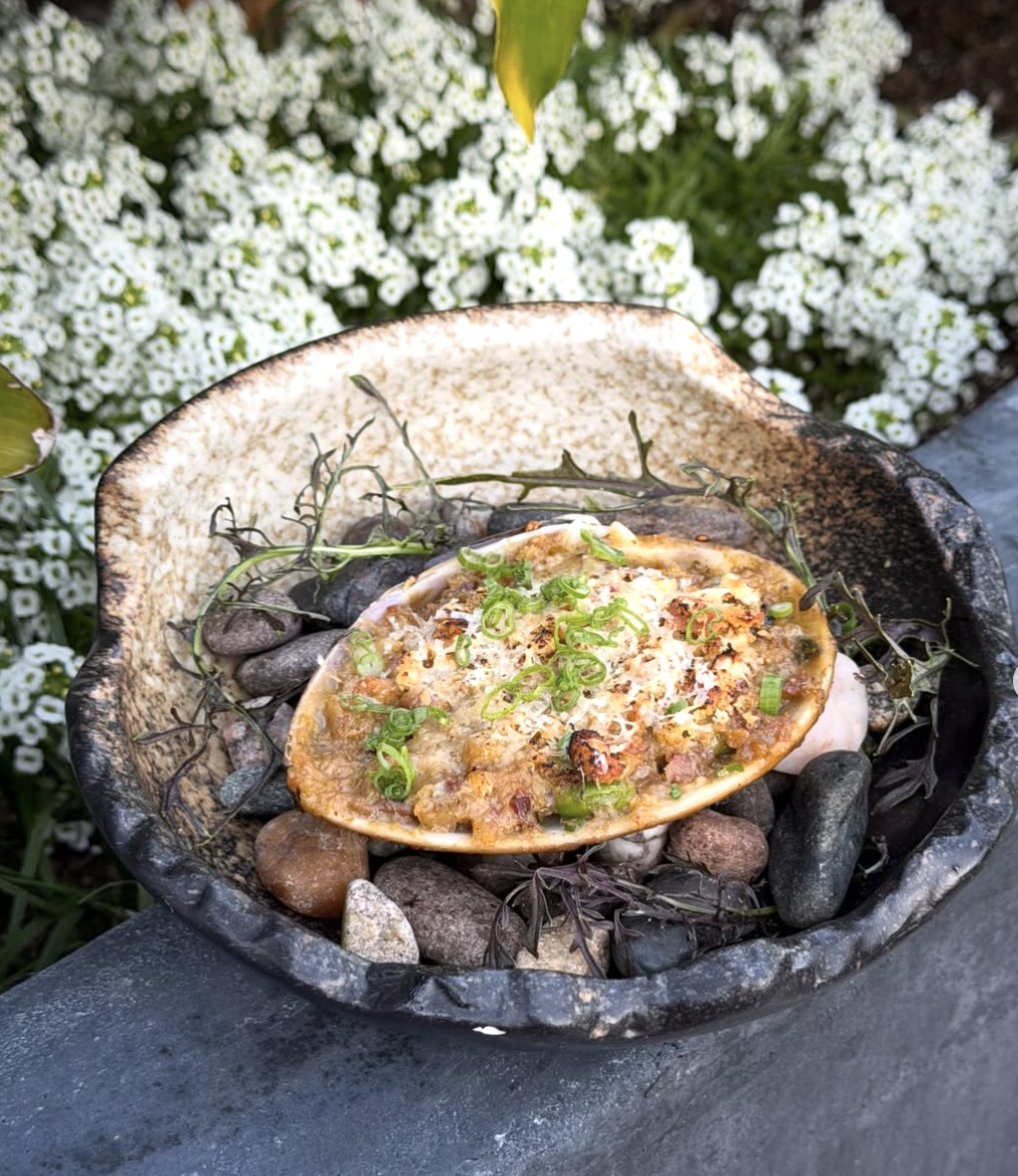 Baked shellfish served in the shell over river stones at Cherryfish in Pacific Beach San Diego